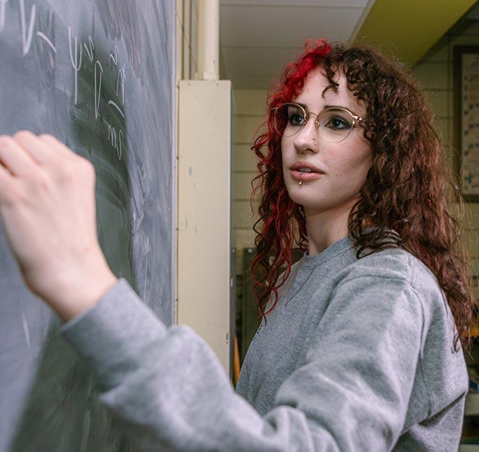 基拉·理查兹在黑板上计算出一个物理公式.
